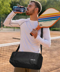 Man holding Set Of 2 Pickleball Paddles With USAPA Approval, Fiberglass Surface And PP Honeycomb Core, with duffel bag on tennis court