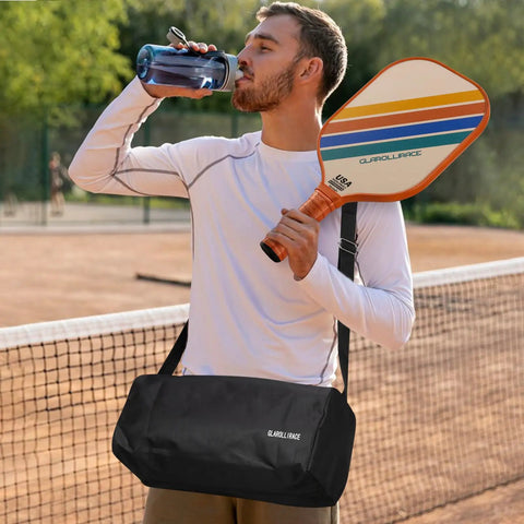 Man holding Set Of 2 Pickleball Paddles With USAPA Approval, Fiberglass Surface And PP Honeycomb Core, with duffel bag on tennis court
