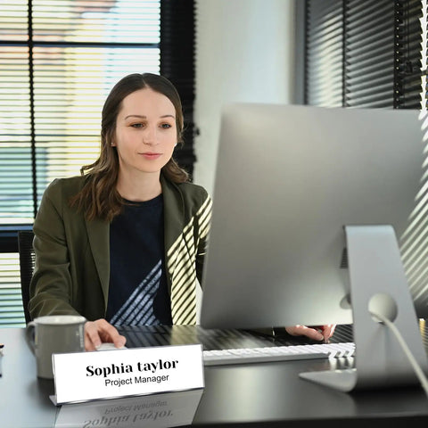 Woman at desk using computer with Pack Of 18 Clear Acrylic Desk Name Plates 2 By 8 Inches Blank Customizable Horizontal Slant.