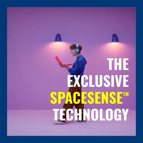 Person walking with laptop in front of purple wall with Smart Tunable White Filament LED Candle Bulb 40W Equivalent With SpaceSense Motion WiFi Connected Voice Or App Control Indoor E26 Base Pack Of 6 Vintage Clear Glass No Fuss Setup Matter Compatible