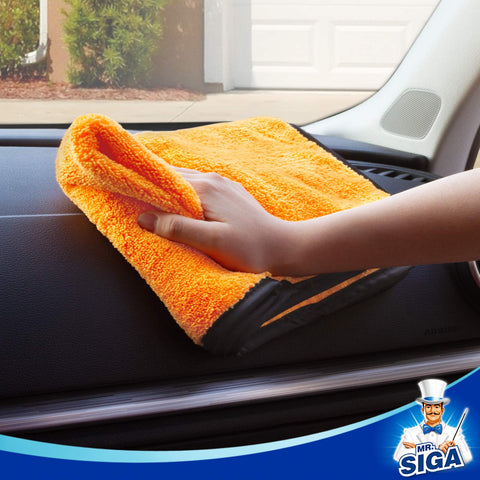 Hand using Ultra Plush Dual-Sided Microfiber Car Towel for washing on dashboard, scratch-free and highly absorbent, gold color