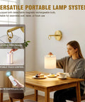 Woman using Zero Drilling Required, Battery Operated Wall Sconces Set Of Two With Remote, Brushed Gold Wireless Hanging Lamps.