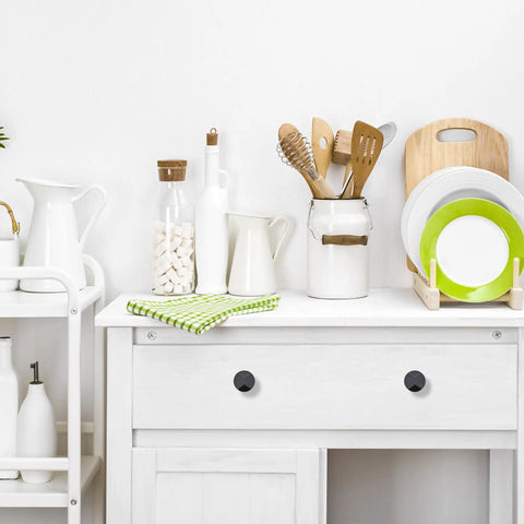 White kitchen cabinet with 25 Pack Matte Black Round Cabinet Hardware Knobs Solid Zinc Alloy One Hole Drawer Pulls For Kitchen Cabinets And Bathroom Furniture Dresser Knobs Dope Durable Easy Install Sleek Modern Look, surrounded by kitchen utensils.
