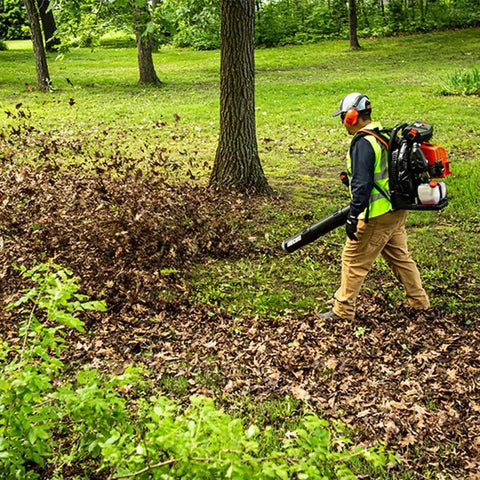 Person using Backyard Beast Gas Backpack Blower With 220 MPH Air Speed 1110 CFM Air Flow 79.9cc 2 Stroke X Series Engine in a yard