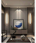 Modern LED Wall Sconce Dropping Chill Ambient Glow With 3000K Up And Down Illumination illuminating a stylish living room.