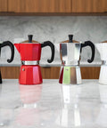 Black, red, silver, and white stovetop espresso makers on marble counter; Stovetop Espresso Maker For Home Brewing And Camping Italian Moka Pot In Classic Aluminum 6 Cup Mocha Pot Easy To Use And Clean Quick Heat Up Portable Silver Sturdy Aluminum Body For Even Heating Durable Construction With Easy Cleanup And Travel Friendly