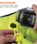 Person activating Evaporative Cooling Vest with 13 oz water, lime color, shows easy use for dry comfort, medium size