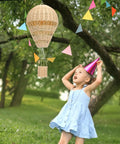 Child gazing at Rattan Hot Air Balloon Decor Set 2 Pcs Wicker Basket Ornaments in outdoor setting.
