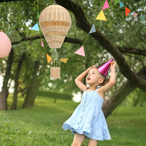 Child gazing at Rattan Hot Air Balloon Decor Set 2 Pcs Wicker Basket Ornaments in outdoor setting.
