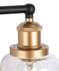 Close-up of Modern Black And Gold Vanity Lights Over Mirror, Four Light Bathroom Fixture with Clear Glass Shades detail