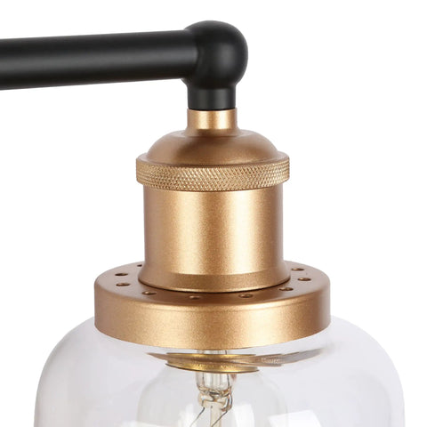 Close-up of Modern Black And Gold Vanity Lights Over Mirror, Four Light Bathroom Fixture with Clear Glass Shades detail