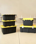 Heavy Duty Plastic Storage Bins With Lids 15 Gallon Black Yellow Six Piece Stackable Tote Set arranged in garage
