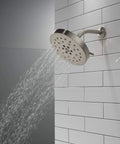 H2Okinetic 4-Setting UltraSoak Shower Head in Stainless Steel mounted on tiled wall with rainlike spray