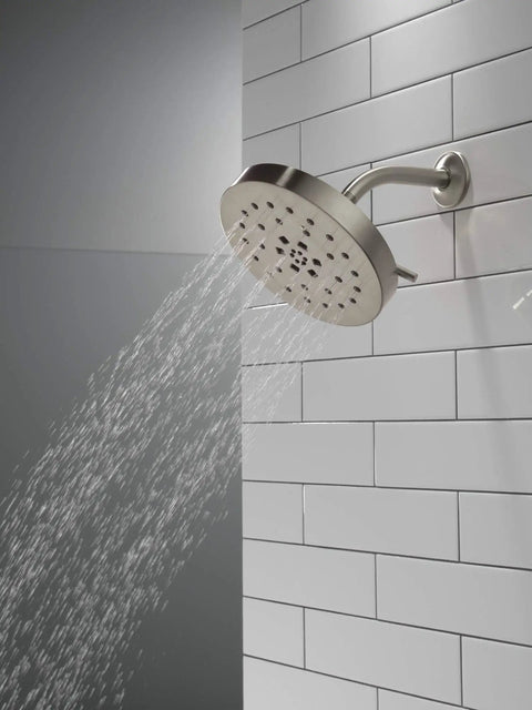 H2Okinetic 4-Setting UltraSoak Shower Head in Stainless Steel mounted on tiled wall with rainlike spray