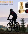 Cyclist with brass Presta to Schrader valve adapters and black caps inset, mountains in background.