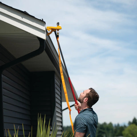 Man installing Badass Wildfire Defense Kit With Two Roof Sprinklers And Fifty Foot Hose on a gutter for fire protection.