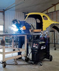 Elite 200 Amp All In One Multi Process AC DC Welder MP200i in garage setting with welder and car frame