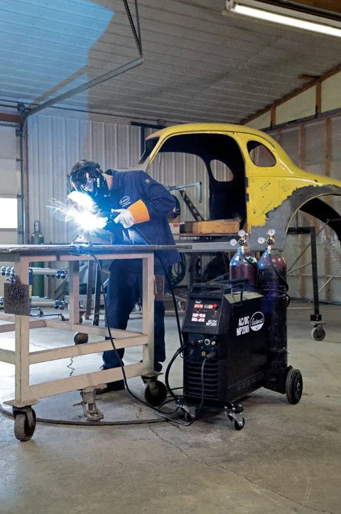 Elite 200 Amp All In One Multi Process AC DC Welder MP200i in garage setting with welder and car frame