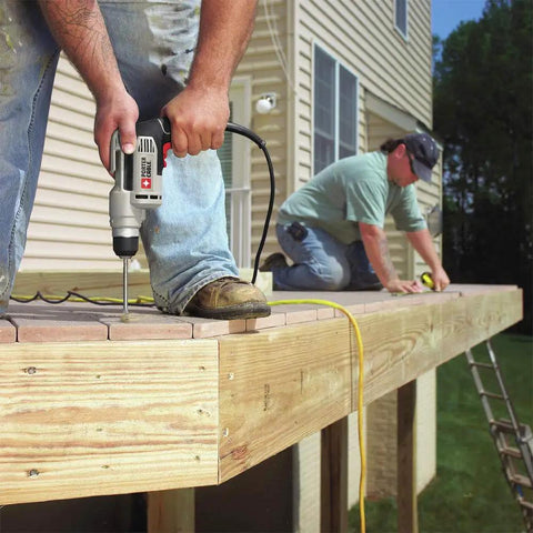 Worker using Corded Drill With Variable Speed From Zero To Two Thousand Five Hundred RPM Six Amp Workhorse Motor Three Eighths Inch Keyless Chuck Easy Bit Changes Belt Clip For Secure Carry And Ideal For Drilling And Driving In Wood Metal And Plastic on a wooden deck