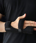 Person wearing Breathable Neoprene Metacarpal Splint For Both Hands Adjustable Left Or Right Finger Support on left hand