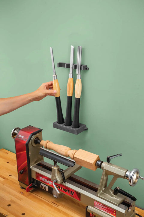 Grab And Go Pro Grade Wall Mounted Tool Organizer with Rare Earth Magnets holds chisels above a woodworking lathe