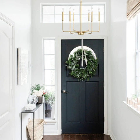 Gold Spray 6 Light Modern Farmhouse Candle Chandelier in entryway with dark door and wreath