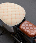 Hella Cozy Beige Plush Motorcycle Seat Cover With Super Warm Winter Fluffy Padding For Riders Seeking A Smooth Ride and Dope Dirt Bike Accessories That Look Clean And Feel Amazing All Day Long, showing quilted beige padding on a bike.