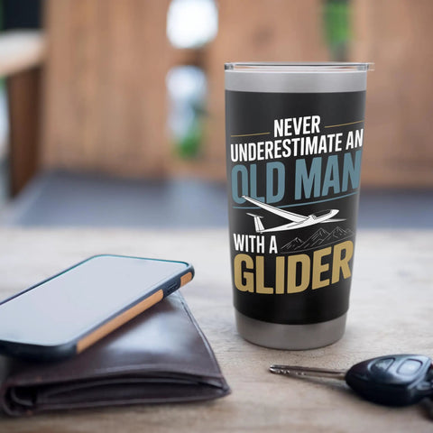Sailplane Pilot Insulated Stainless Steel Tumbler For Glider Club Members And Aviation Fans on a table with wallet and keys.
