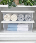 Heavy Duty Clear Plastic Storage Bins With Secure Snap On Lids Super Solid Twelve Quart Capacity Sweet Four Pack storing rolled towels in a closet.