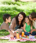 Family picnic with Beefy Heavy Duty Metal Tent Stakes Set 17 Pack securing blanket, showing 4mm thick galvanized steel pegs.