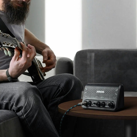 Person playing guitar with Beast 10W Mini Guitar Amp For Bedroom Practice Portable All-In-One Bluetooth Amp on table