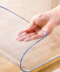 Clear 14 x 24 Inch Table Cover Protector Waterproof 2mm Thick Vinyl Desk Mat in hand, showing flexibility and clarity.
