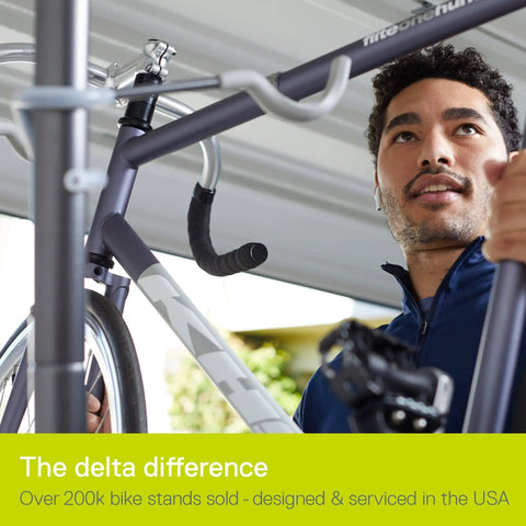 Man adjusting bicycle on Michelangelo Gravity Two Bike Storage Rack No Drill Wall Lean Vertical Bike Holder.