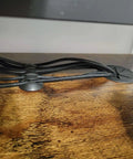 16 Pack Black Cable Clip Organizer Set with Adhesive Backing installed on wood desk, managing cords and USB cables neatly.
