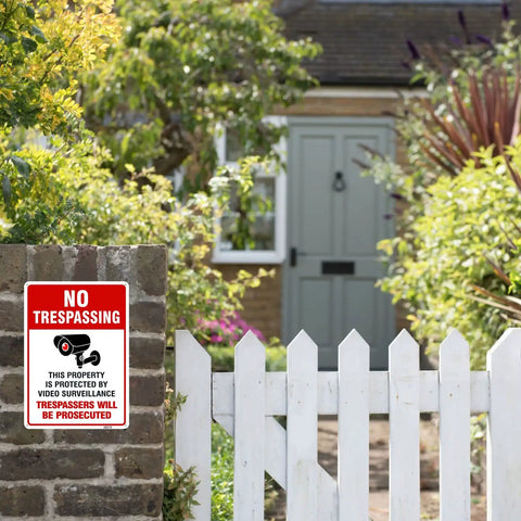 Straight Up Legal Deterrent Video Surveillance And No Trespassing Signs 4 Pack Aluminum Security Plates Weather Resistant red white sign on stone wall in garden