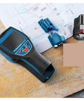 Heavy Duty Stud Finder Wall Scanner With Slick Visual Center Marker Detects Metal Wood Water Pipes Live Cables And Electrical Wires Dual Power Setup For Tight Spaces Zero Sweat Operation on a wooden surface with plans.