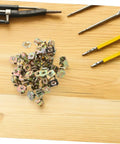 50 Pack Premium Automotive Fastener Clips Golden Iron Captive Nuts arranged on a wooden surface with tools.