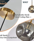 Brass Gold Globe Pendant Light Lit With Smoke Gray Glass Shade Mid Century Modern Ceiling Hanging Fixture close-up details