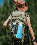 Backpacker with collapsible soft flask water bottle for on-the-go hydration, ergonomic easy squeeze, attached to backpack