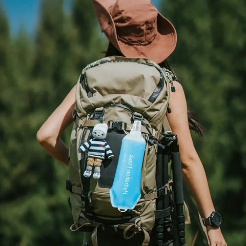 Backpacker with collapsible soft flask water bottle for on-the-go hydration, ergonomic easy squeeze, attached to backpack