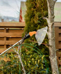 Transparent Windproof Spray Nozzle With Drift Guard attached to a garden sprayer for crop treatment in outdoor setting.
