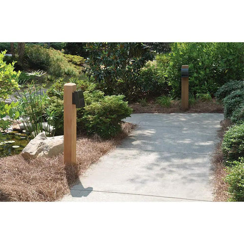 Crosstour 26W Carbon Outdoor Integrated LED Wall Pack with bronze finish illuminating a garden pathway