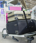 Luggage cart at airport with 1 Inch By 10 Foot Adjustable Cam Buckle Tie Down Straps Set securing suitcases, black, 4 pack