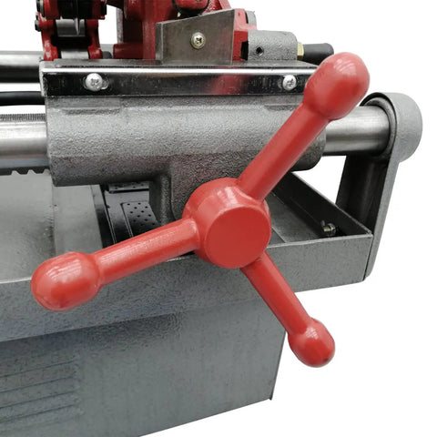 Electric Pipe Threader Workhorse One Half To Two Inch NPT With Twenty Eight RPM Threading Cutter Three In One Tool For Threading Cutting And Reaming Includes Clamping Device And Oiling System Built For Construction And Installation Jobs close-up of red handwheel and pipe clamp
