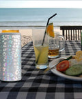 Laser Leopard Skinny Can Cooler Made With Double Wall Vacuum Insulated Stainless Steel To Keep Your Twelve Ounce Tall Boys Frosty All Night Long Perfect Bridesmaid Party Favors That Truly Hit Different on a beach table with drinks.