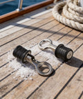 Two 1-1/4 Inch Drainage Outlet Seals with stainless steel body and rubber core on a boat deck, shown in a marine environment.