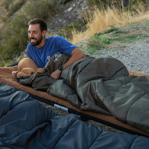 Man relaxing in 0 Degree Sleeping Bag For All Weather Camping Cozy And Warm With Roomy Half Circle Mummy Hood Flannel Lining