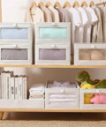 4 Pcs Foldable Closet Storage Bins With Clear Window For Slick Organization And No Sweat Folding To Keep Your Wardrobe Tidy And Make Room Organization A Total Breeze, on wooden shelf with clothes and books.