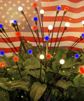 Solar Powered Patriotic American Flag Lights 4 Pack for Outdoor Garden Decor, red white blue glowing bulbs among green leaves