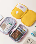 Open Must Have Emergency First Aid Bag Grab And Go Medical Kit with customizable compartments, yellow nylon pouch on desk.